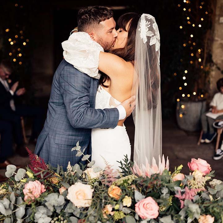 Bride & groom kiss on their wedding day during ceremony