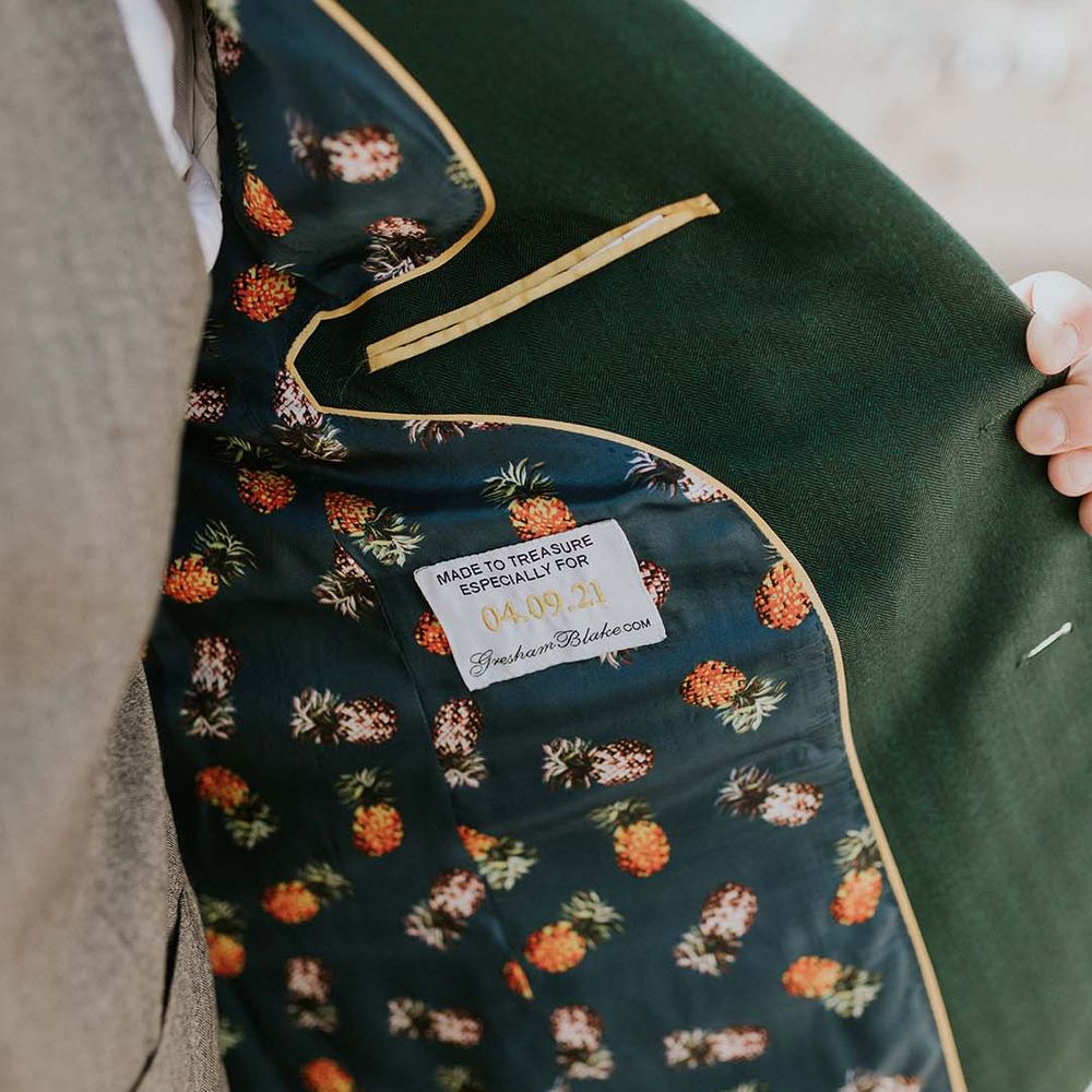 Groom wears green jacket complete with lining with pineapple fabric