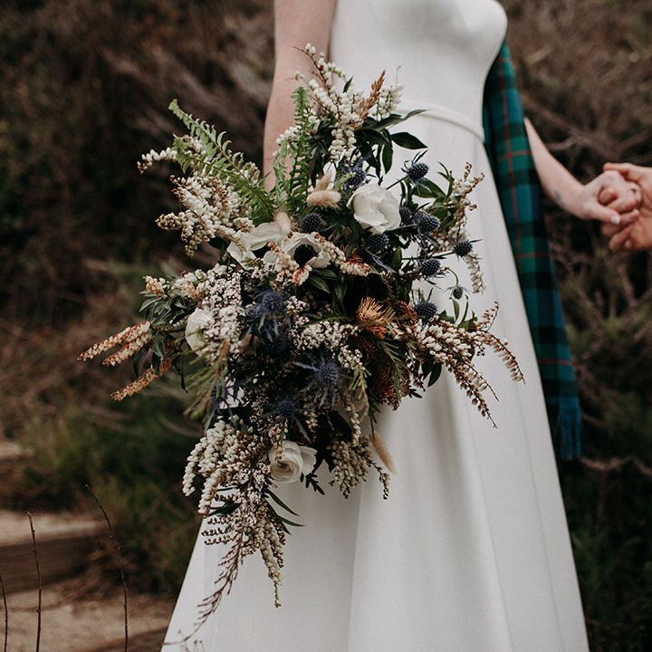 neutral wedding bouquet with anemones, ranunculus, thistles and wildflowers