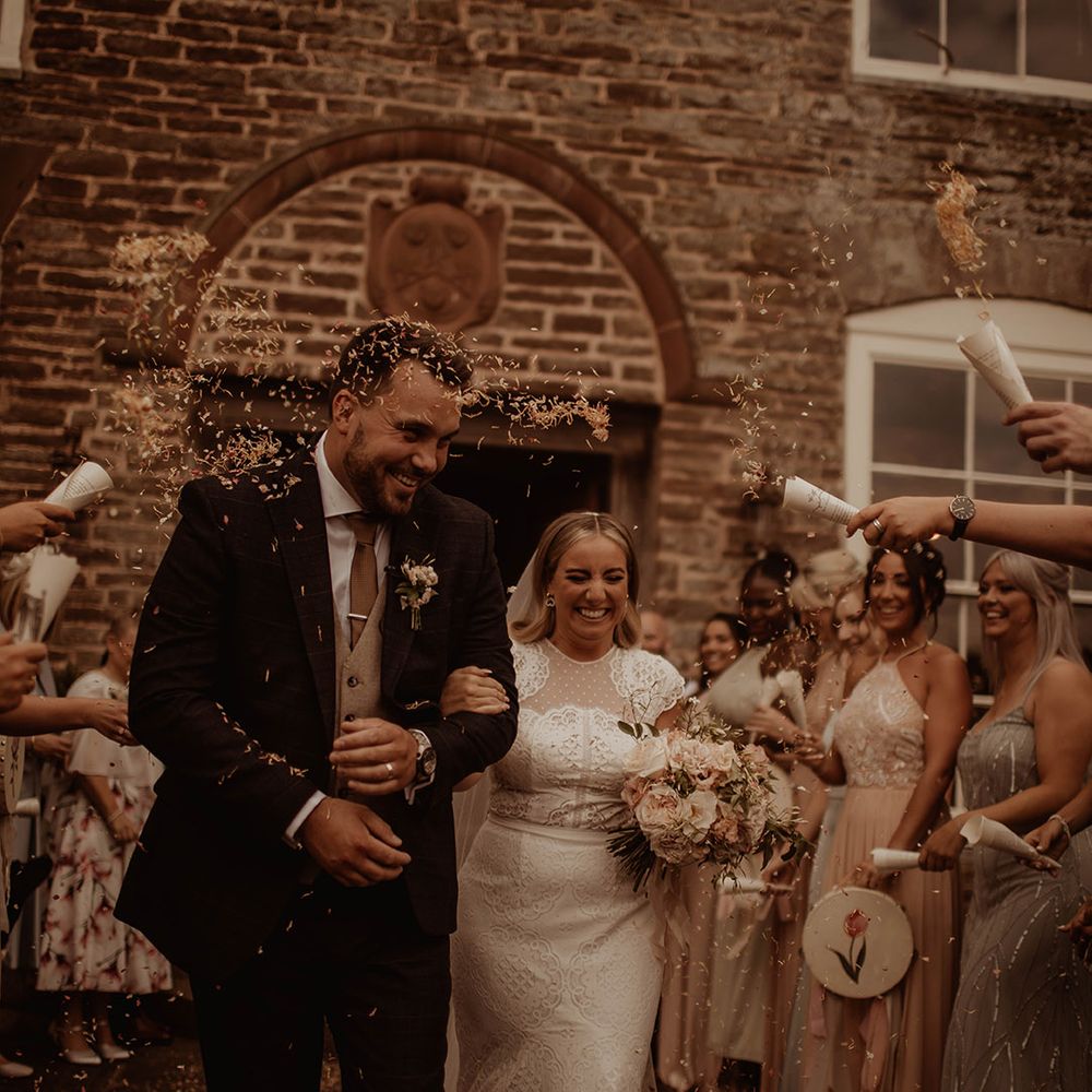Confetti moment at Dewsall court with bride in a lace cap sleeve wedding dress