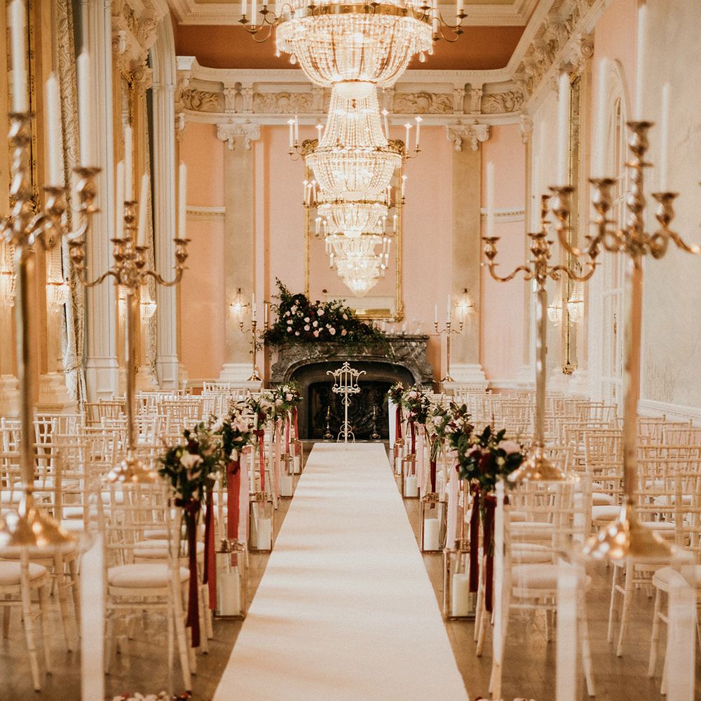 Beautiful ceremony decor with crystal chandeliers and flower chair decor