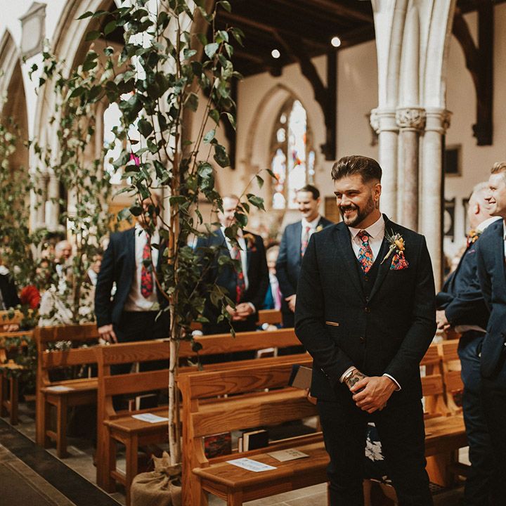 Groom and best man at the church altar in a navy suit and floral Liberty print tie