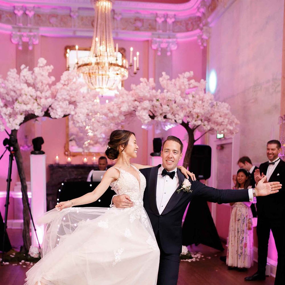 Groom lifts his bride and spins her during first dance at wedding ceremony