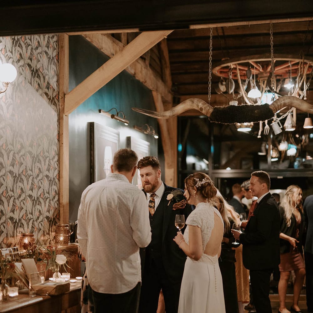 Bride in Rosa Clara open back dress mingles with wedding guests at The Barns at Redcoats 
