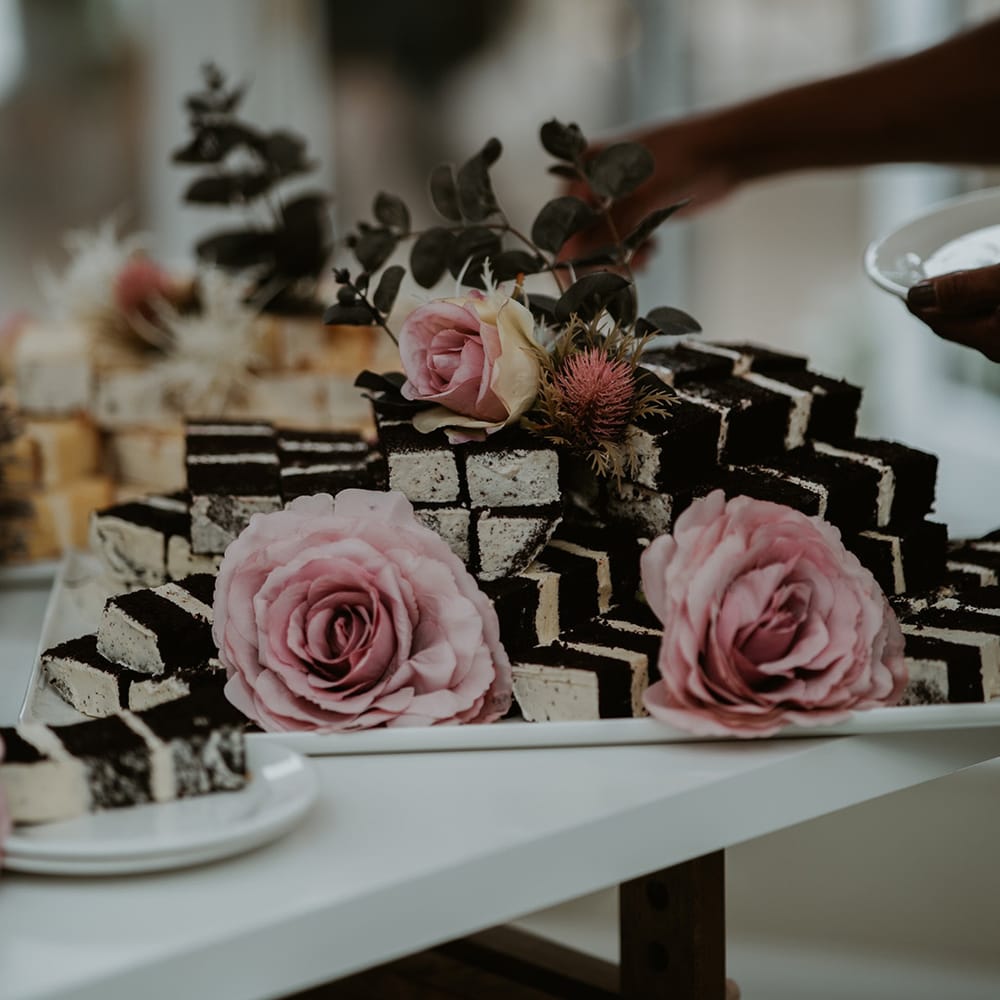 Chocolate wedding cake cut into slices complete with pink roses 