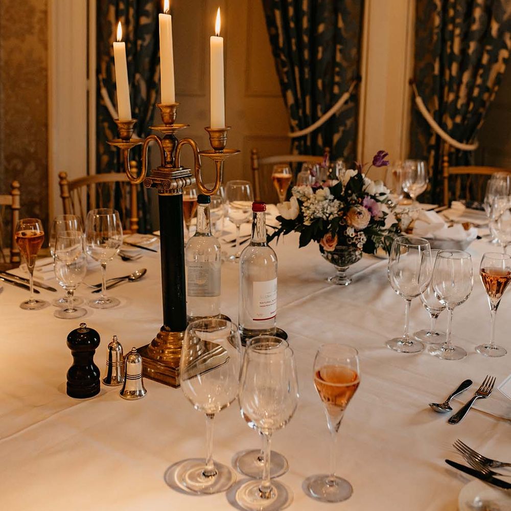 Wedding tablescape with three pronged golden and black candlestick and mixed floral arrangement