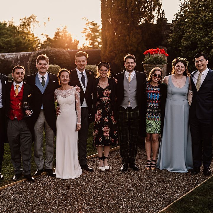 Bride and groom pose with some of the wedding party at golden hour 
