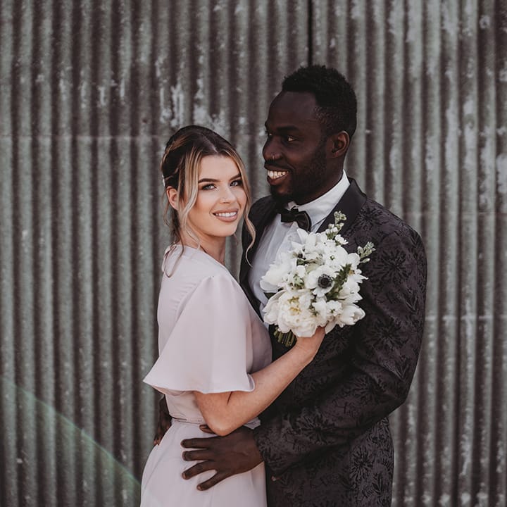Bridesmaid in a pale pink dress with the groomsman in a patterned suit jacket for wedding at Willow Grange Farm