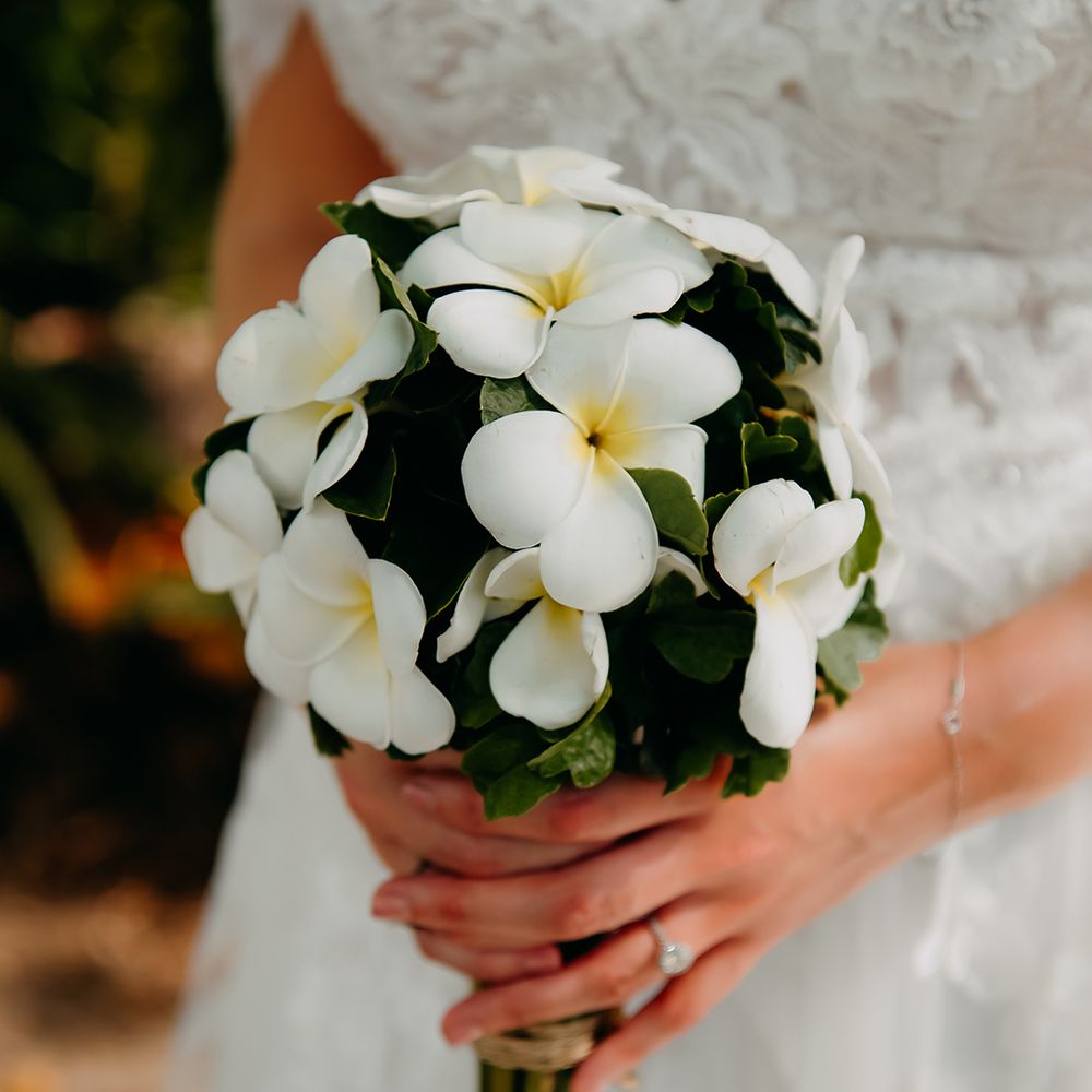 Bride holding white tropical flower bouquet 