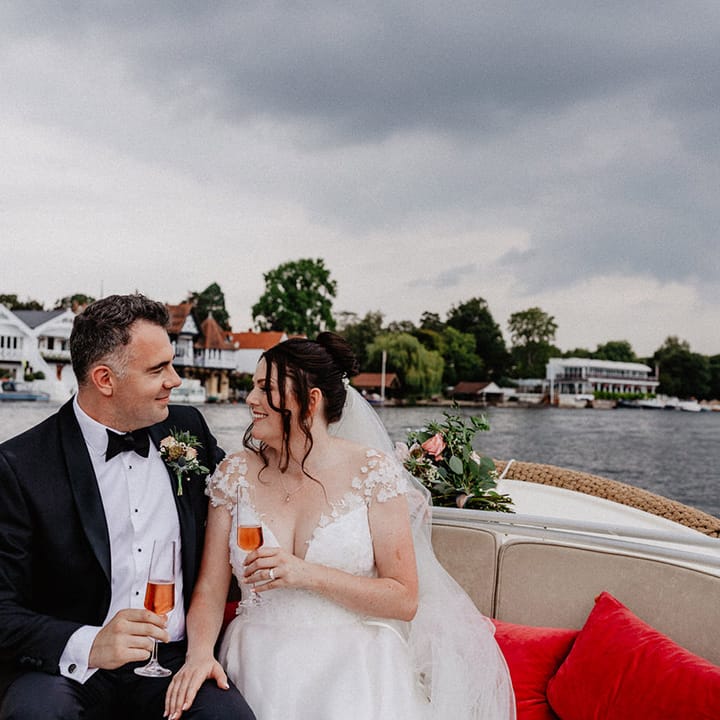 The bride and groom share some wine on their boat ride around Henley on Thames 