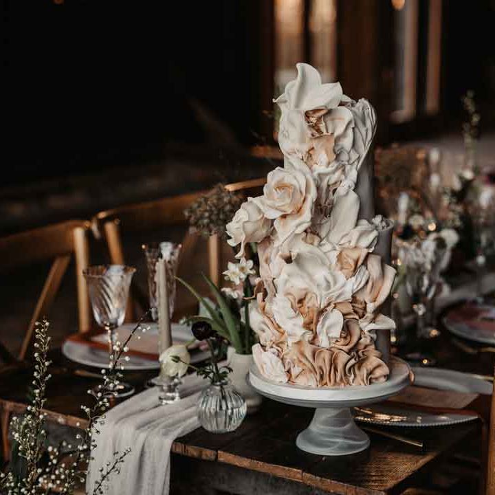Edgy, modern artistic three tiered wedding cake with layered icing in the shape of roses