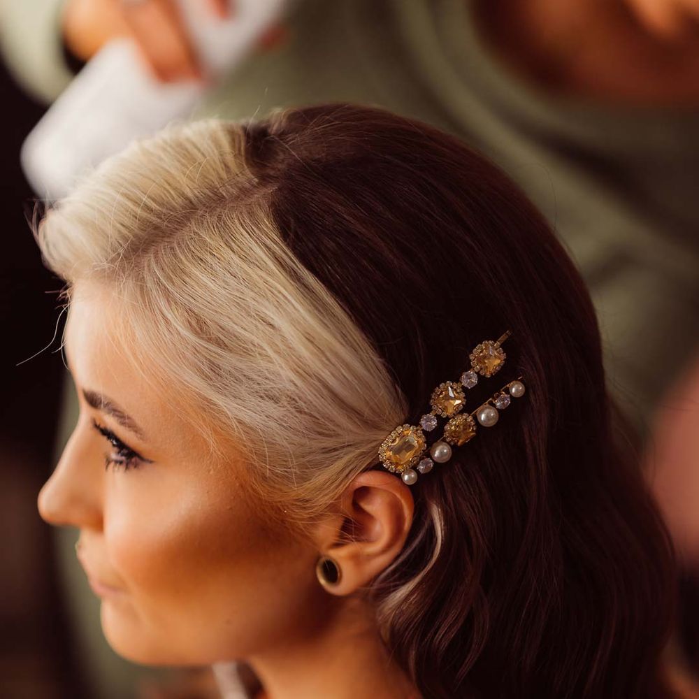 Bride with two toned dyed hair wearing burnt orange getting ready robe and pearl and stone bridal hair slides 