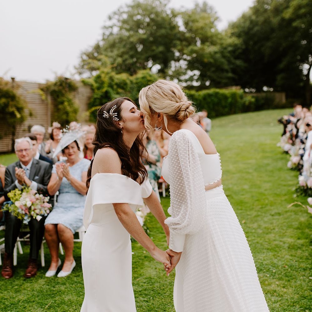 Two brides share their first kiss together at their outdoor ceremony in Dorset 