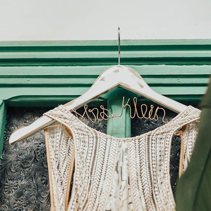 Customised coat hanger with wire spelling out the bride's new last name 