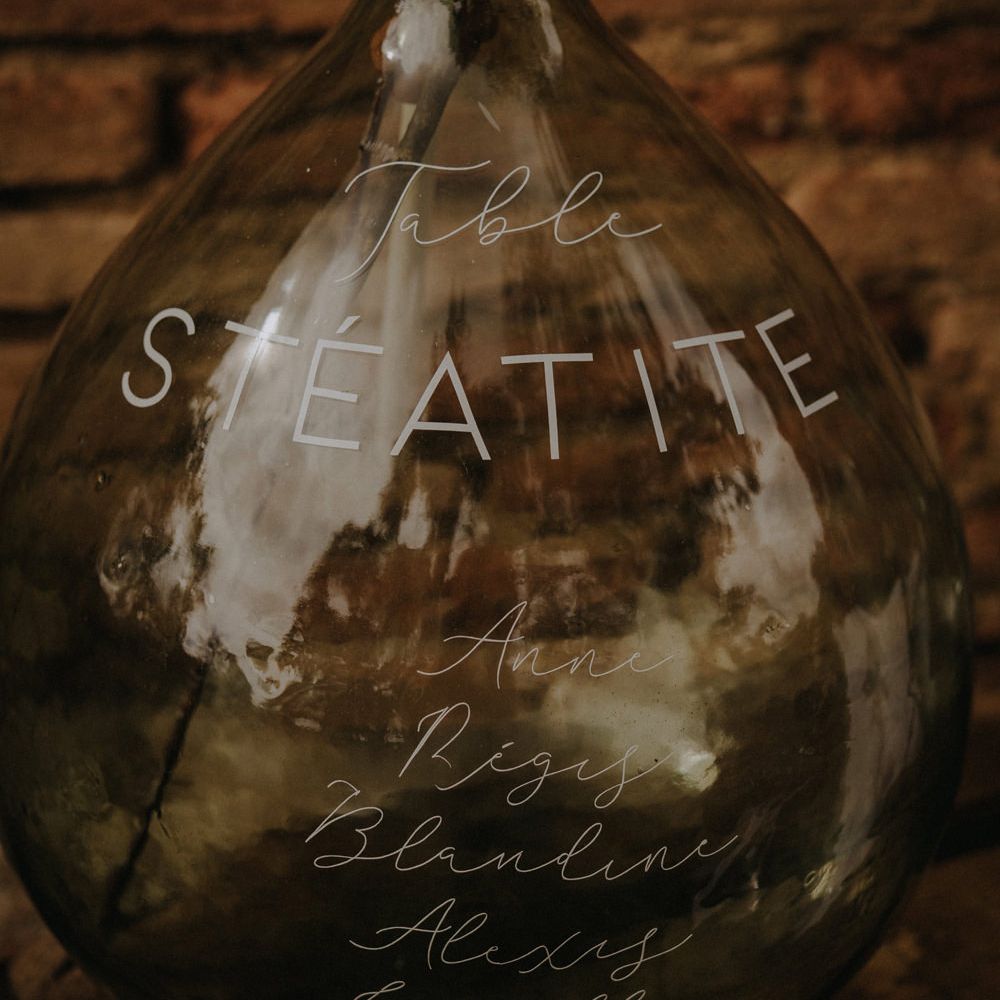Seating chart written on an apothecary jar in white ink 