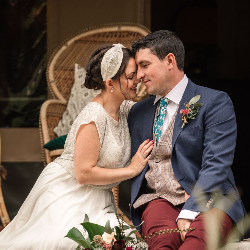 Bride & groom kiss whilst sat together in safari inspired shoot