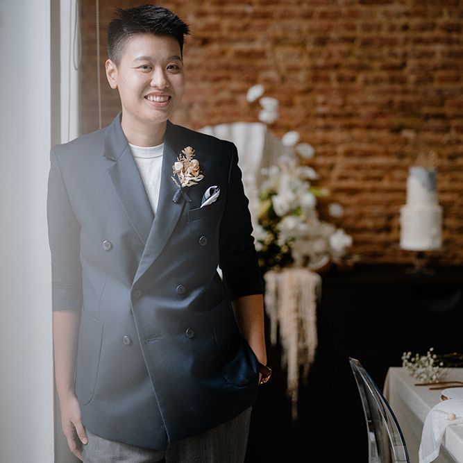 Asian Lesbian bride in a white t shirt and navy double breasted suit jacket 