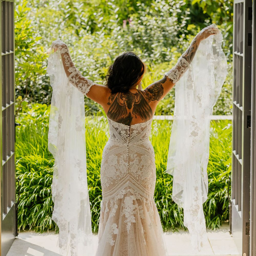 Bride in a lace wedding dress with mermaid tail and detachable bell sleeves for fiesta theme wedding 