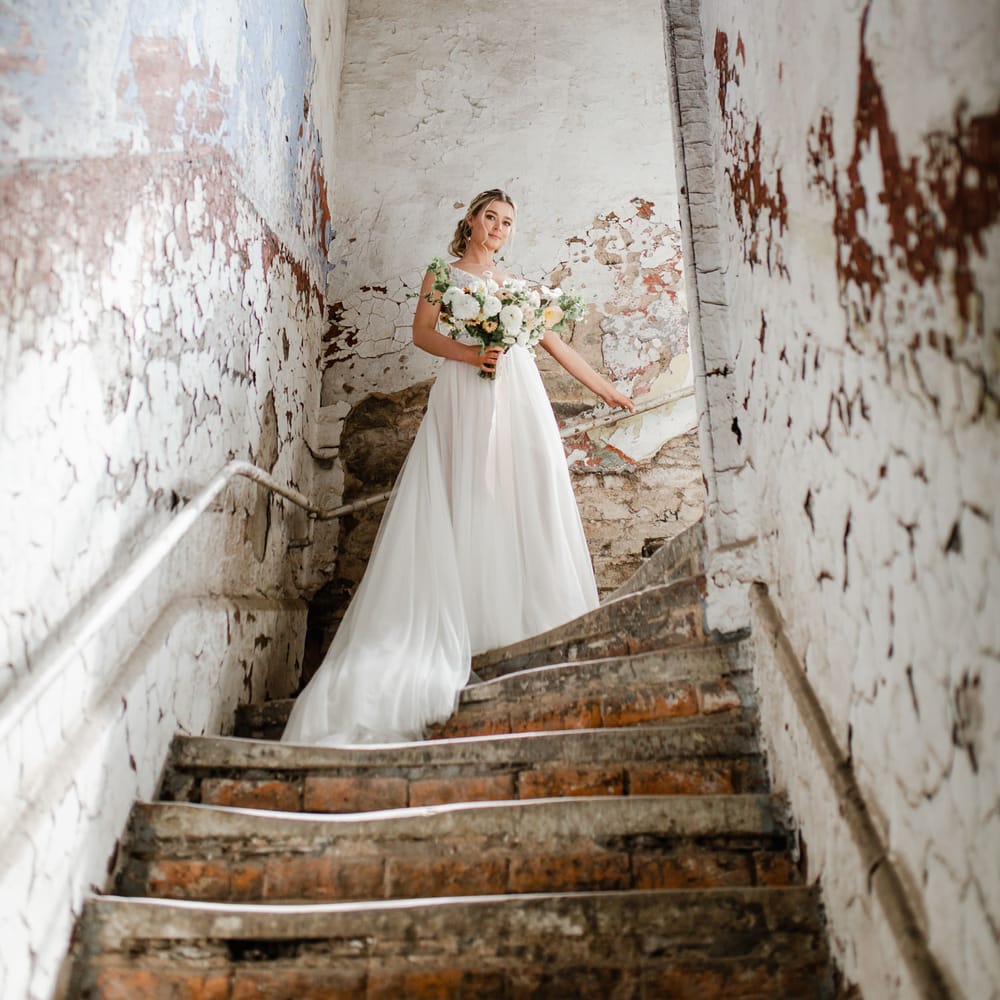 Bride in a tulle skirt wedding dress standing in a corridor at Torr Vale Mill industrial wedding venue in Derbyshire 