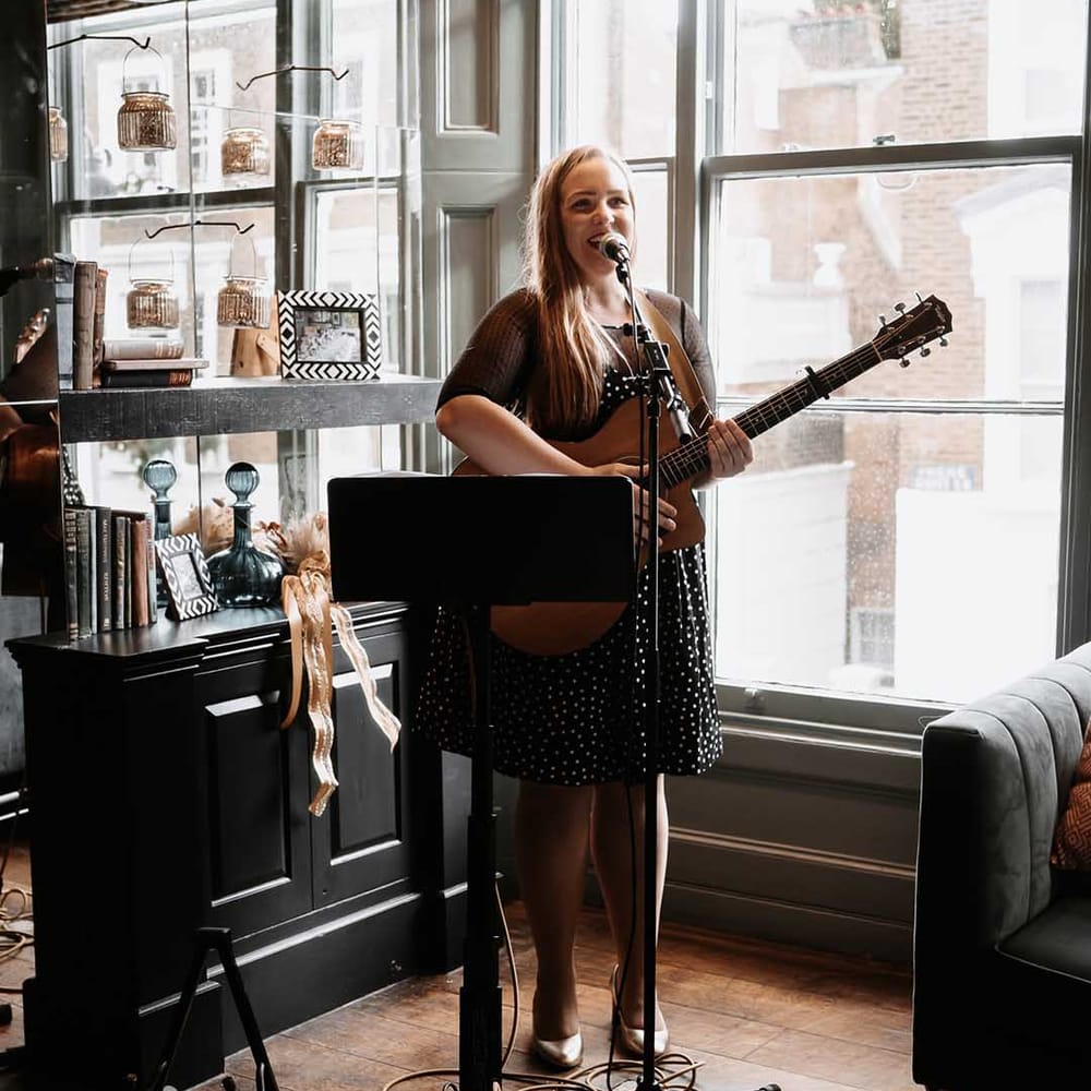 Lady guitar entertains wedding guests at Chelsea Town hall wedding