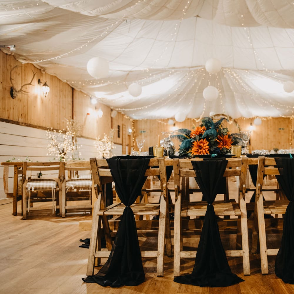 Rustic wedding reception with wooden chairs, tables and fairy lights for Wellbeing Farm wedding in Lancashire