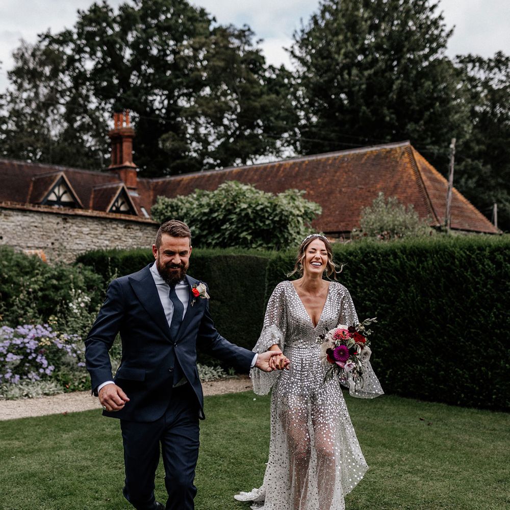 Groom in navy suit and bride silver sparkly wedding dress