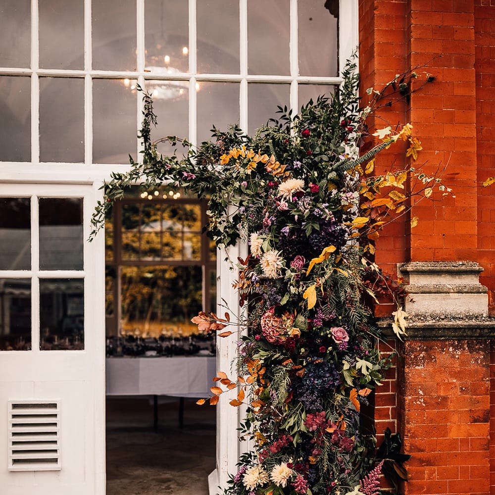 Flower arrangement full of autumn colours & a range of different flowers 