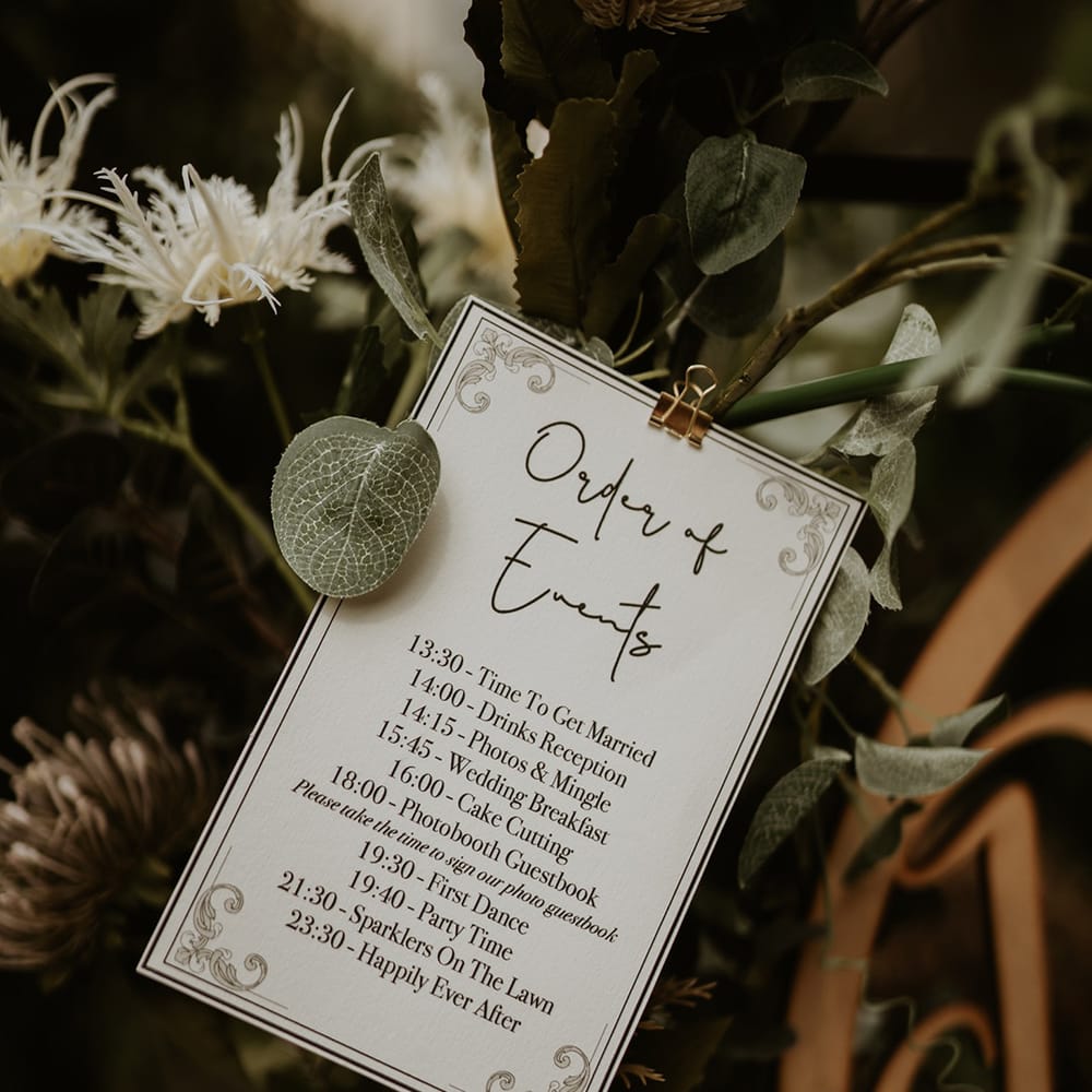 Order Of Service stationery surrounded by green foliage 