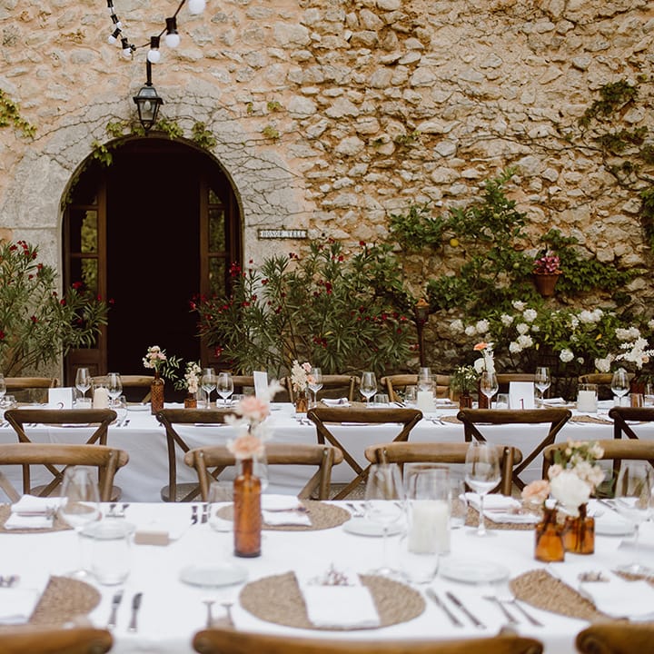 Tables set for the guests with pink and white flowers 