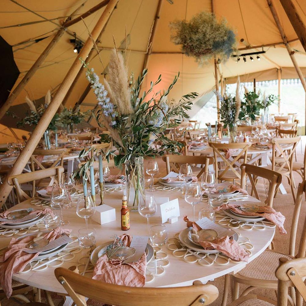 Table setting in Buffalo Tipi reception area with pastel pink and blue theme and large gypsophila cloud 