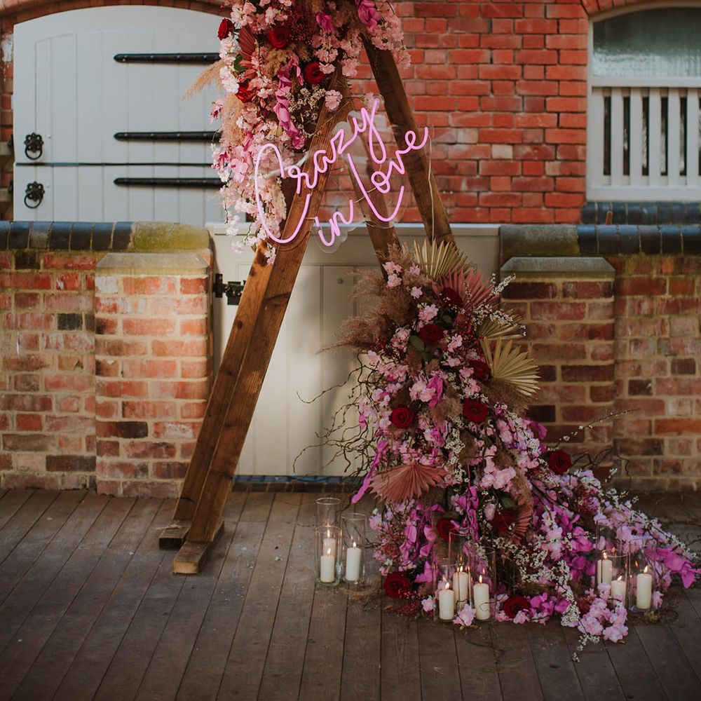 Wooden triangle altar Fram decorated with cherry blossom and a Crazy in Love neon sign 
