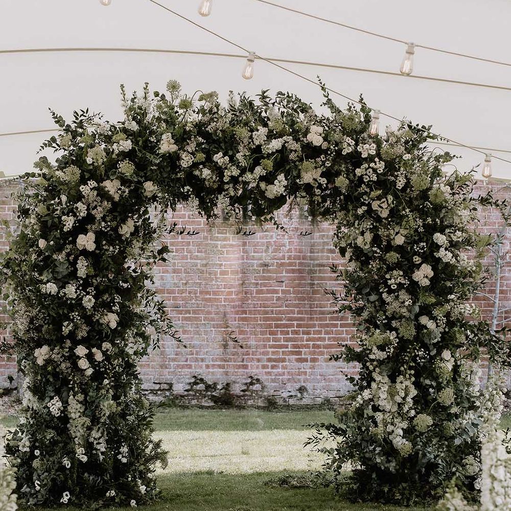 White flower wedding arch for altar decoration at outdoor marquee wedding 