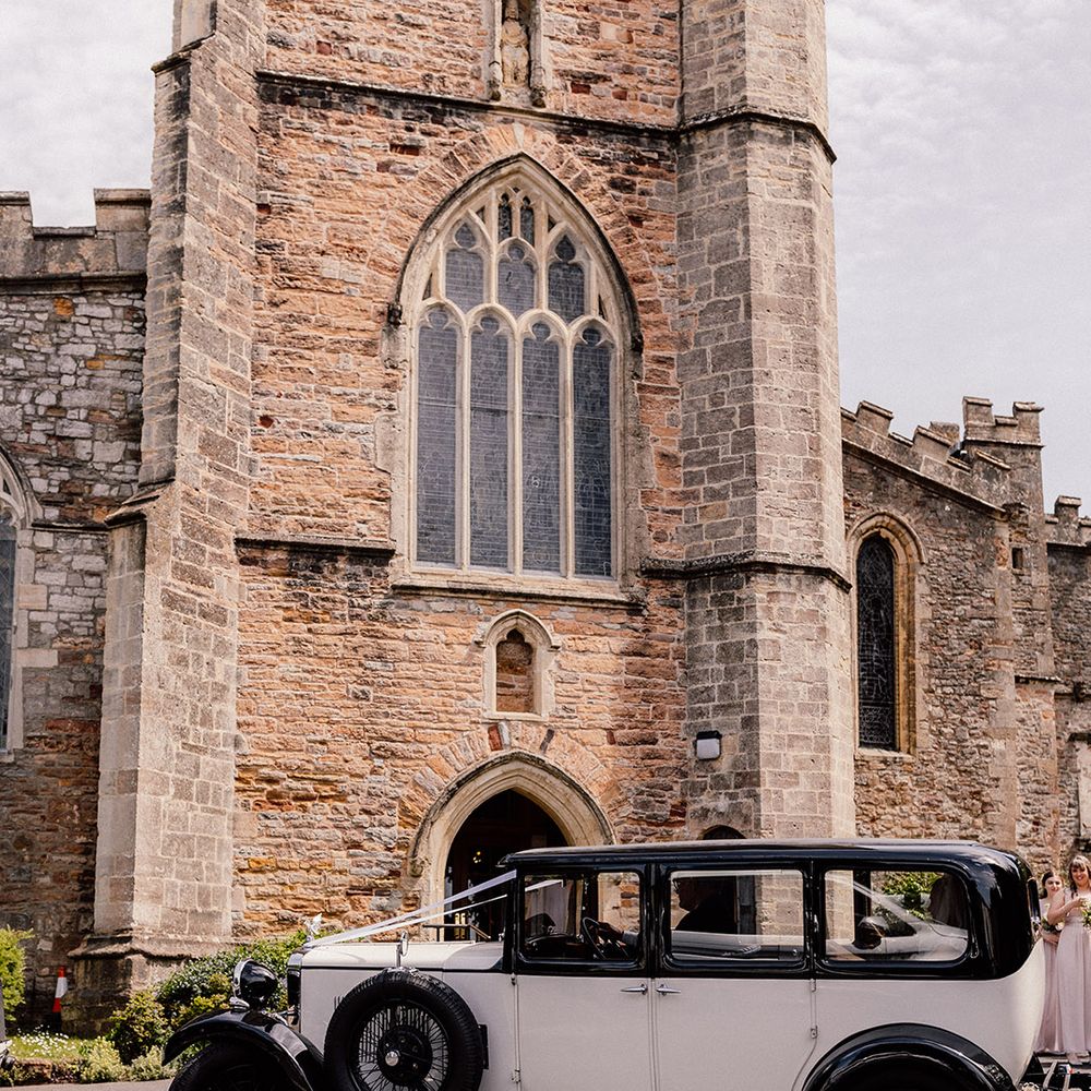 Black and white vintage wedding car transportation for traditional church wedding 