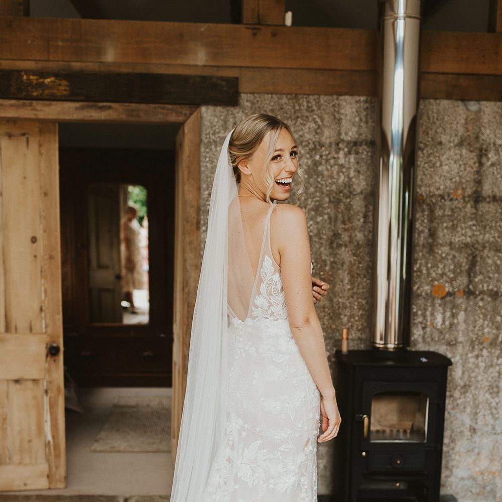 Bride in a low black lace wedding dress from Made With Love Bridal for her rustic style wedding day 