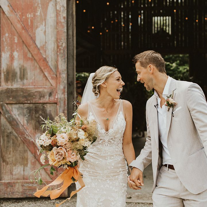 Bride and groom smile at each other as they exit their ceremony as husband and wife 