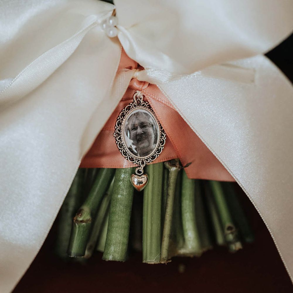 Wedding bouquet with white bow and pink ribbon and a personalised charm of a family member 