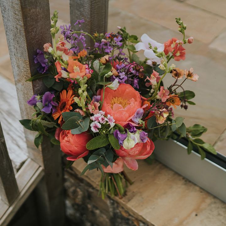 Colourful floral bouquet with orange peonies and green foliage 