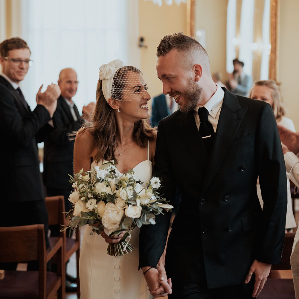 Chelsea registry office wedding with bride in separates and birdcage veil holding a white and green wedding bouquet 