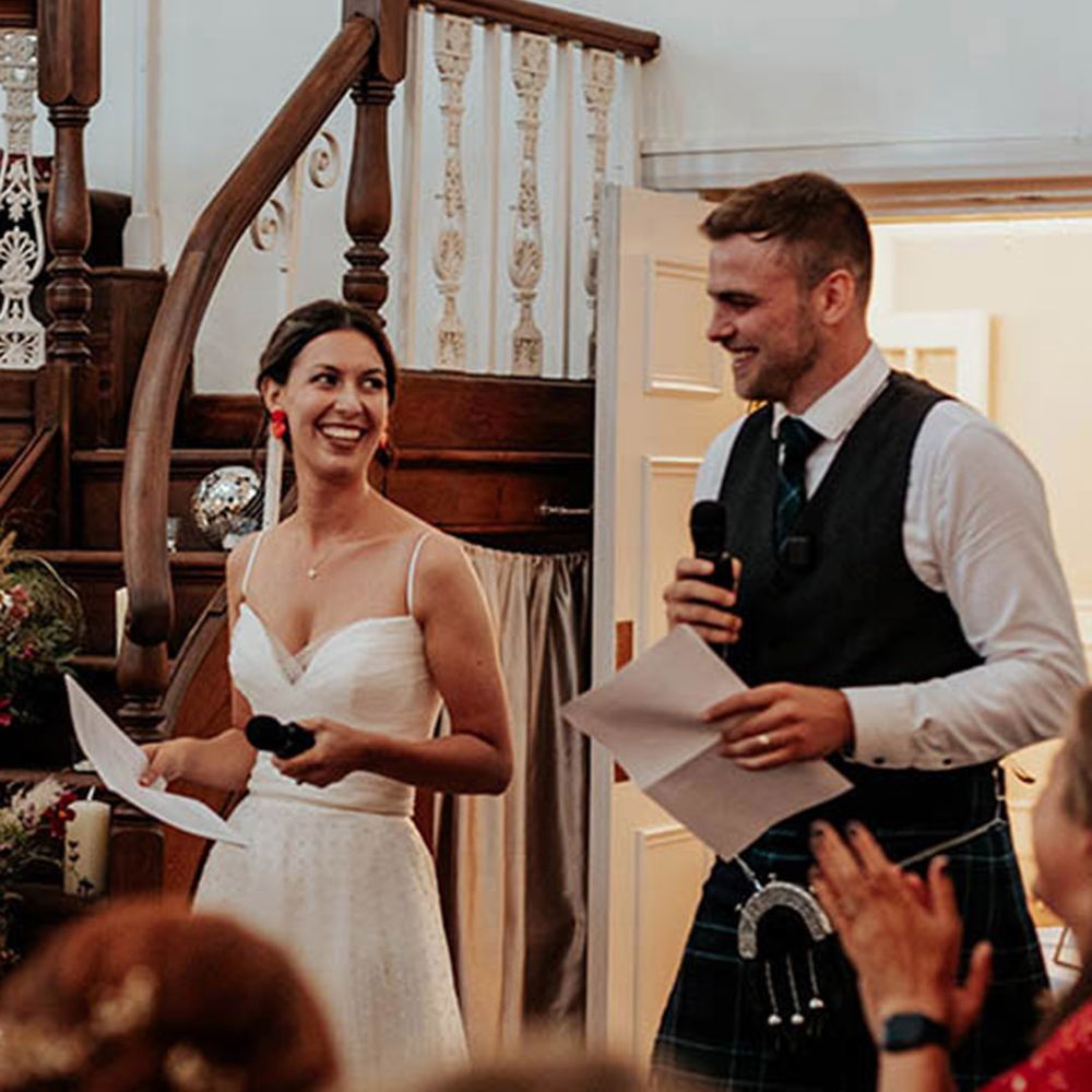 The bride and groom read out their joint wedding speech at barn wedding 