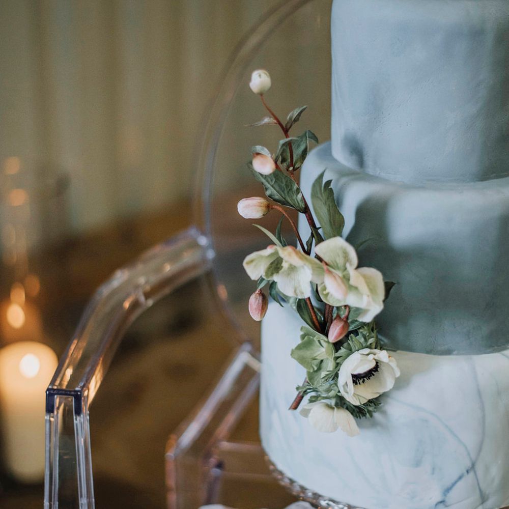 Powder blue tiered wedding cake with floral decorations 