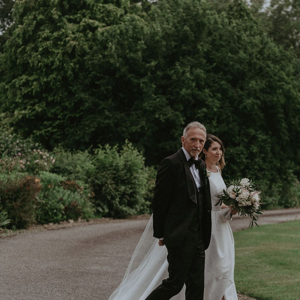 Bride walks down the aisle with her father on the day of her wedding