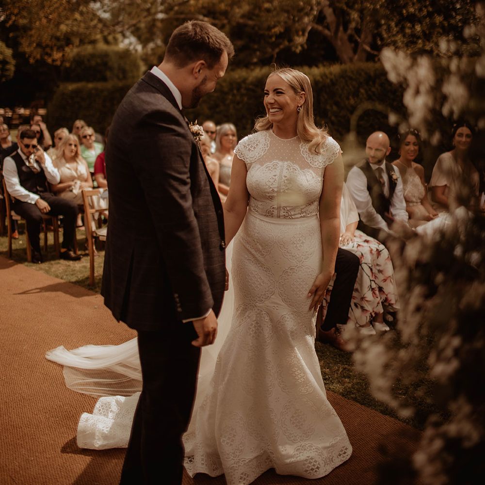 Outdoor Dewsall Court wedding ceremony with bride in a lace wedding dress