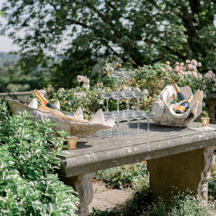 Champagne tower on stone table outdoors as the sun shines