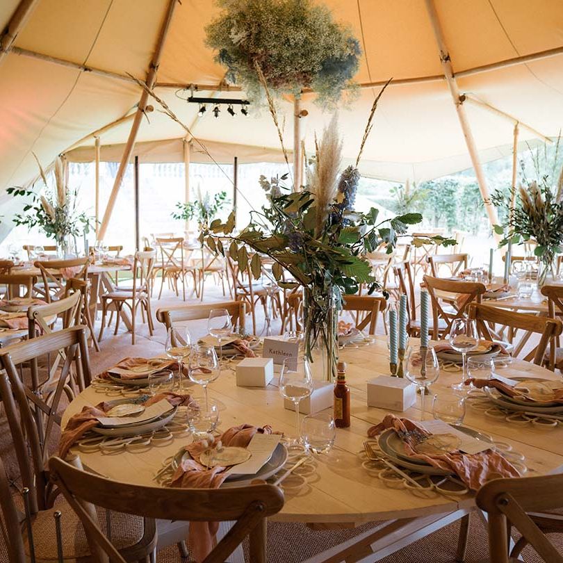 Tablescape with blue twisted candles, dried flower bouquets with pastel colourings and pink napkins with gypsophila cloud
