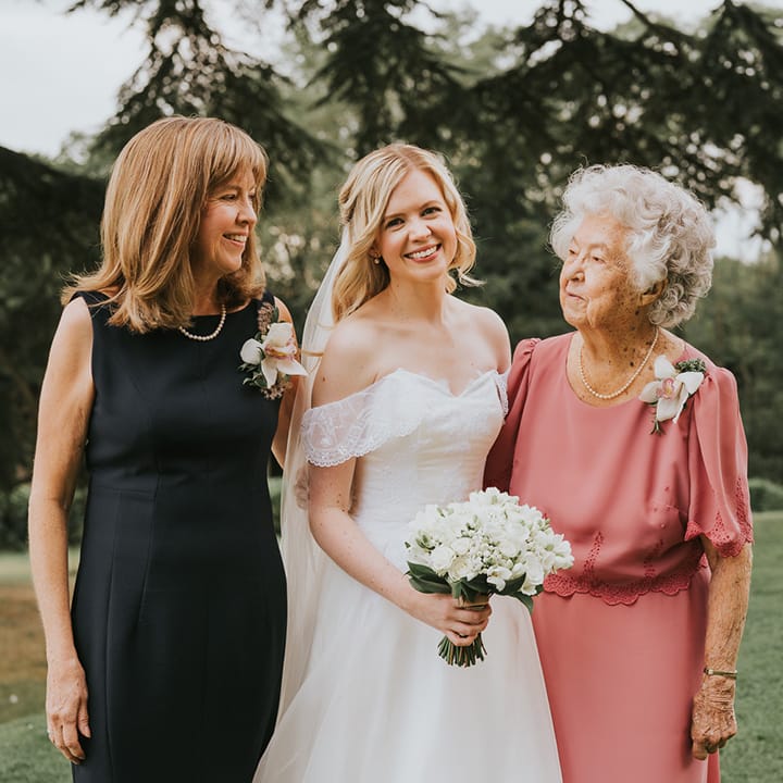 Bride with half up half down wedding hair in ballgown wedding dress with wedding guests 