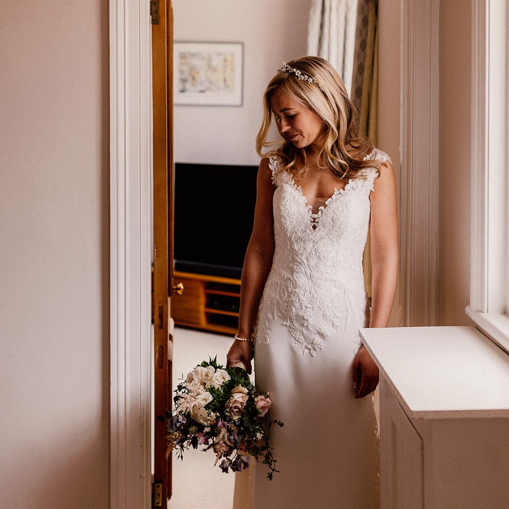 Bride in lace top wedding dress with train and pearl headpiece 