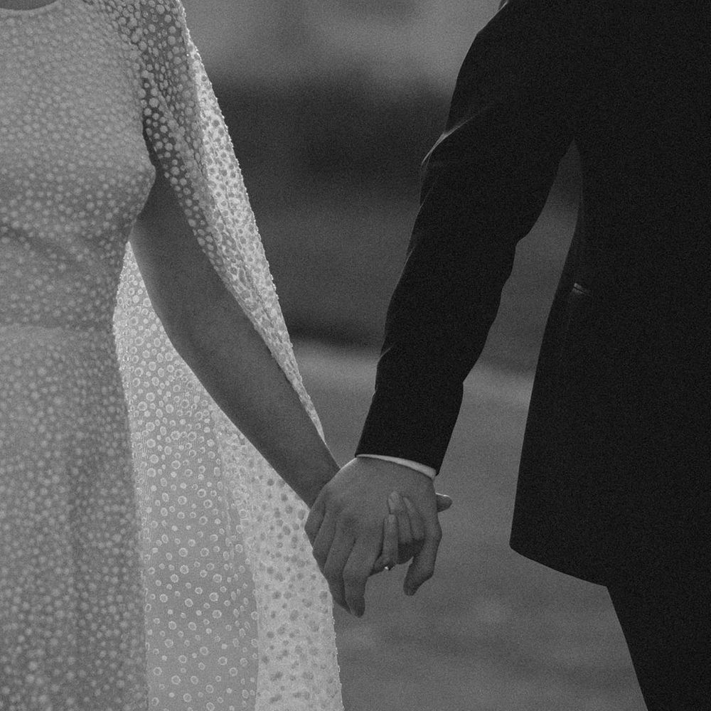 Bride and groom walk holding hands 