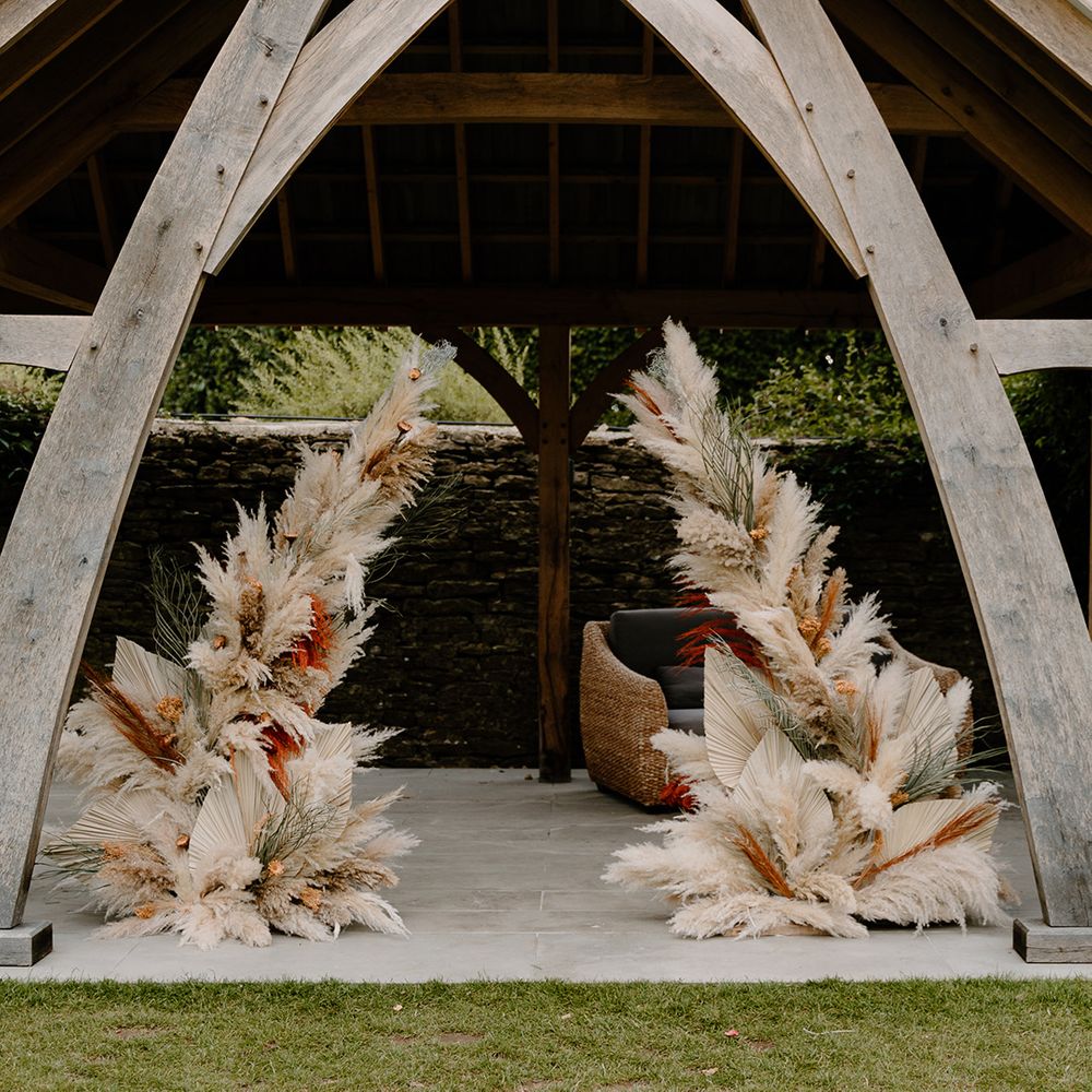 Two pampas grass columns decorate the outdoor altar at The Great Tythe Barn Tetbury