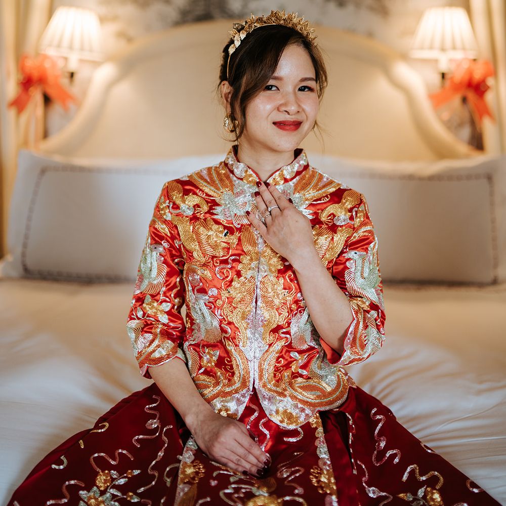 Bride wears traditional Chinese wedding dress with red and gold embellishment and gold bridal crown