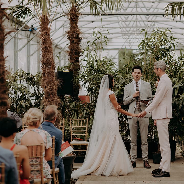Bride and Groom hold hands during wedding ceremony at Architectural Plants Venue
